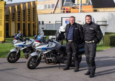 Dwóch policjantów w mundurach stojących przy motocyklach.