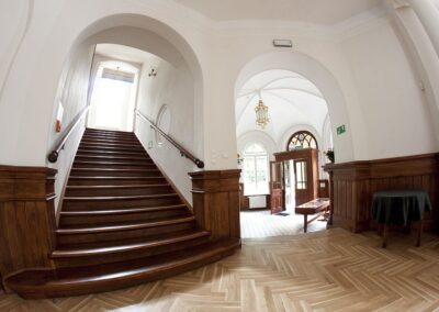 Drewniane schody i wejście do pałacu z drewnianym wiatrołapem.
