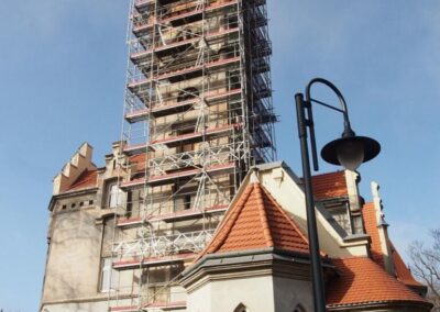 Wieża pałacu w Nakle Śląskim przykryta rusztowaniem.