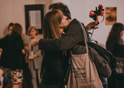 Rektor ASP przytulający autorke wystawy i wręczający jej kwiaty.