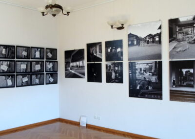 Widok rogu sali , na obu ścianach układy czarno-białych zdjęć.