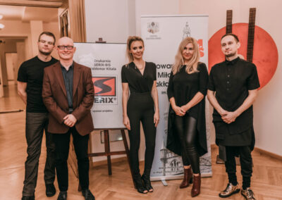 Członkowie zespołu oraz prezes Stowarzyszenia Miłośników Nakła Śląskiego oraz Dyrektor Centrum stoją na tle baneru stowarzyszenia i logo Serix.