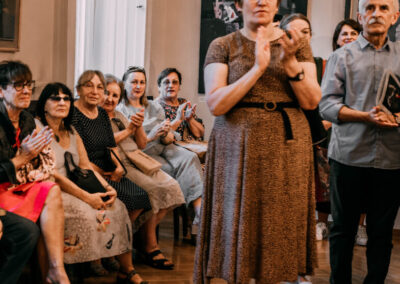 Ludzie klaszczą w dłonie podczas wernisażu wystawy Rafała Stępniaka pod tytułem na granicy abstrakcji.