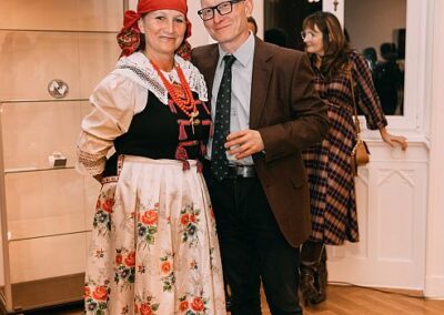 Dyrektor Stanisław Zając wraz z kobietą ubraną w strój ludowy pozują do zdjęcia podczas promocji kalendarza CKŚ.